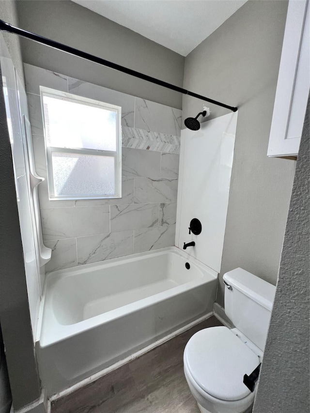 bathroom featuring hardwood / wood-style floors, toilet, and tiled shower / bath