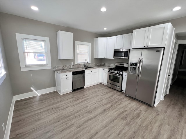 kitchen featuring white cabinetry, light hardwood / wood-style floors, a healthy amount of sunlight, and appliances with stainless steel finishes