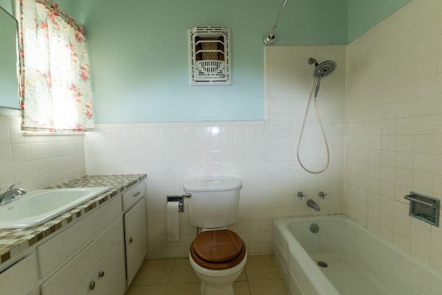 full bathroom featuring toilet, tiled shower / bath, vanity, tile walls, and tile floors