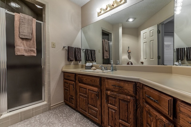 bathroom with an enclosed shower, oversized vanity, and a textured ceiling