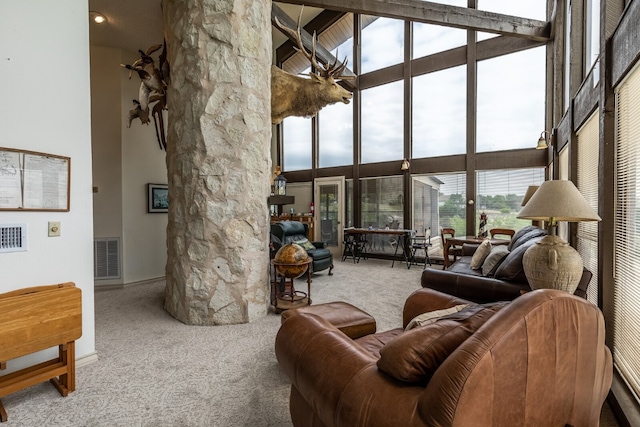 carpeted living room with a towering ceiling