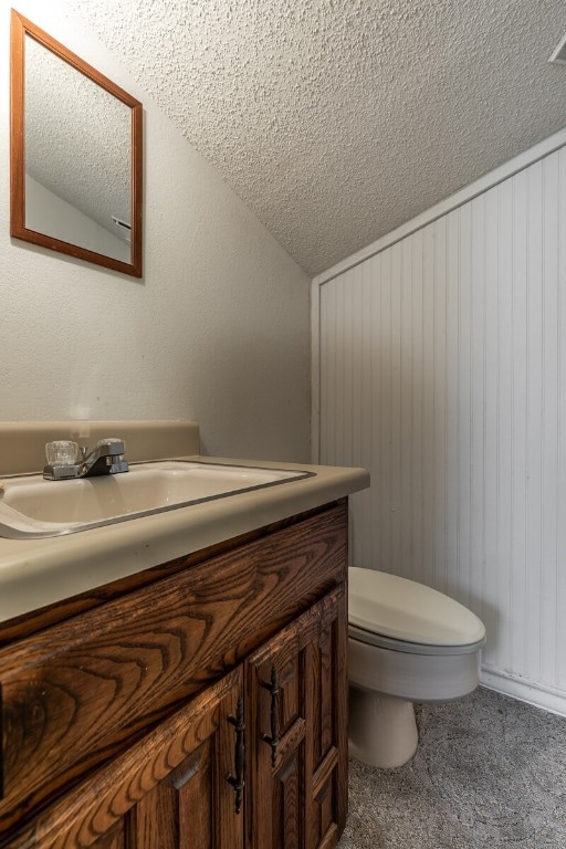 bathroom with a textured ceiling, toilet, and vanity