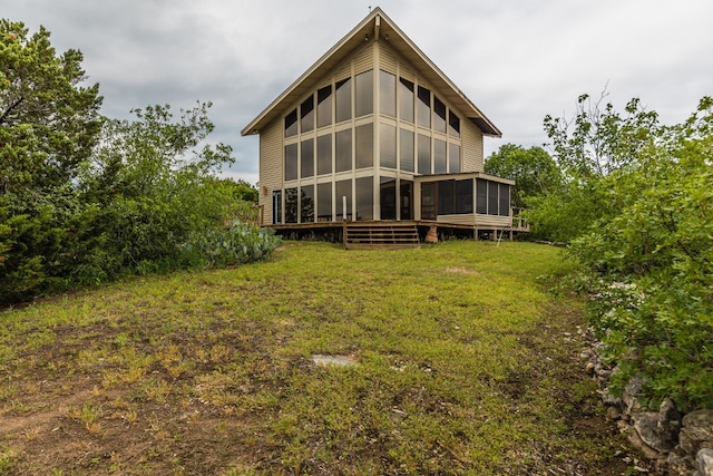 rear view of house with a sunroom and a lawn