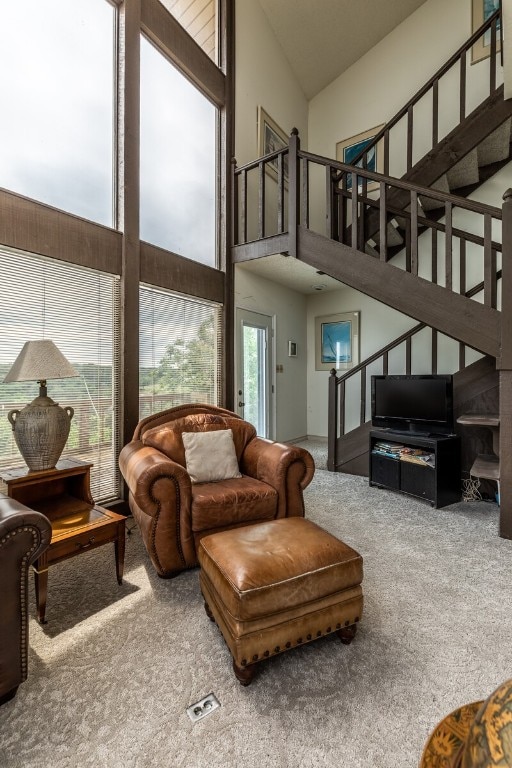 carpeted living room featuring high vaulted ceiling