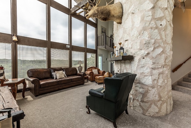 living room with a wealth of natural light, a towering ceiling, and carpet