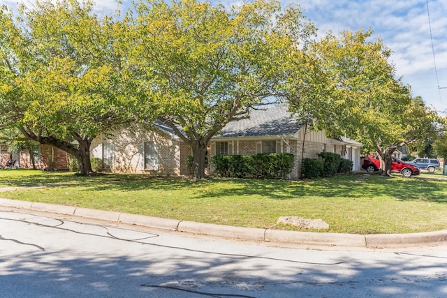 view of property hidden behind natural elements with a front lawn