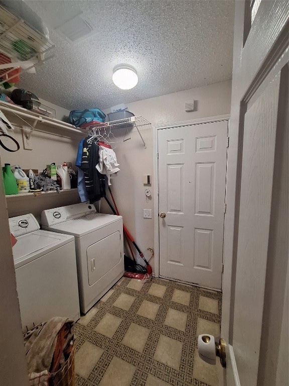 laundry room with independent washer and dryer and a textured ceiling