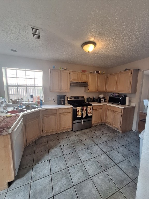 kitchen featuring light brown cabinets, a textured ceiling, electric range, and light tile flooring