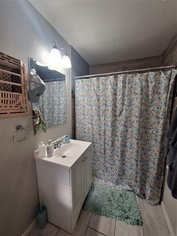 bathroom featuring tile floors, vanity, and a textured ceiling