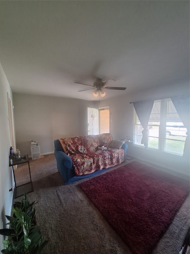 living room featuring a wealth of natural light, ceiling fan, and carpet flooring