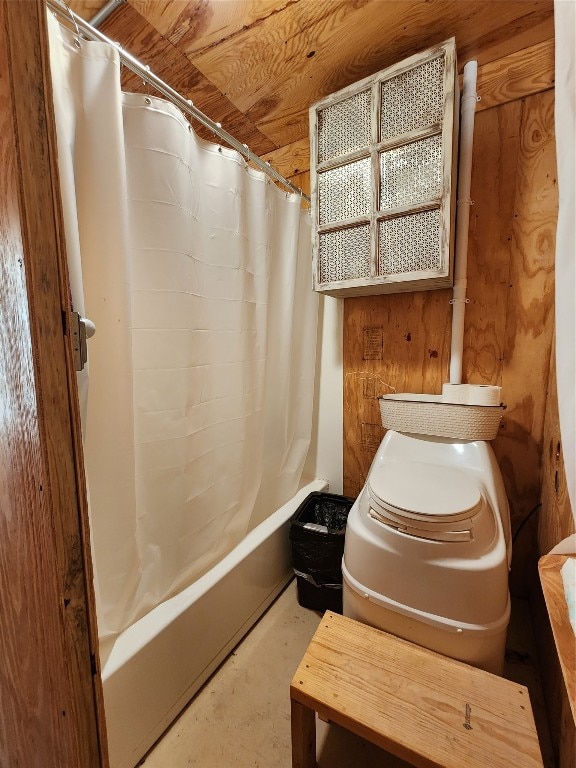 bathroom with wooden walls, toilet, wooden ceiling, and shower / bathtub combination with curtain