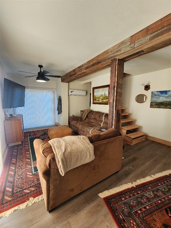 living room featuring an AC wall unit, hardwood / wood-style floors, and ceiling fan