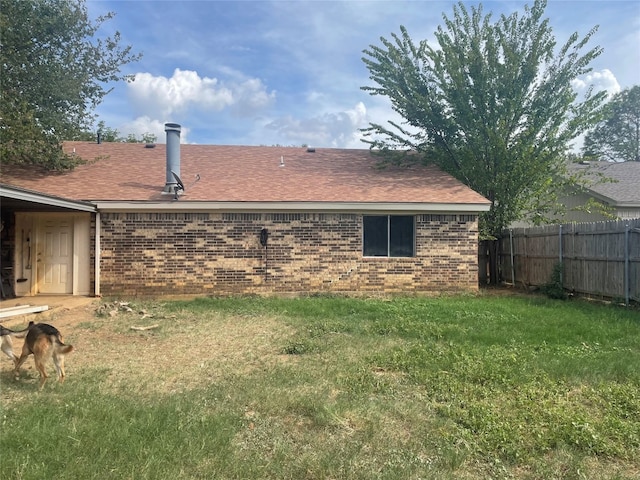 rear view of property featuring a yard