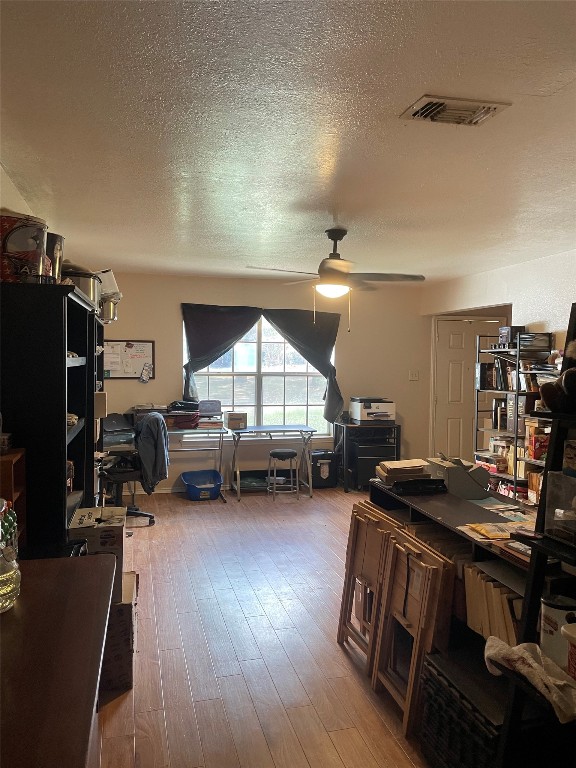 office area featuring ceiling fan, a textured ceiling, and dark hardwood / wood-style flooring