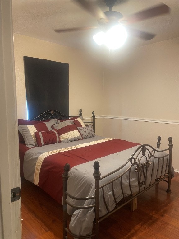 bedroom with ceiling fan and dark wood-type flooring