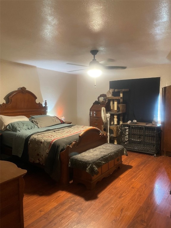 bedroom featuring ceiling fan, a textured ceiling, and dark wood-type flooring