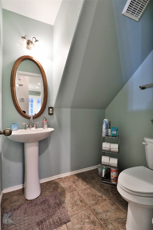 bathroom featuring toilet and vaulted ceiling