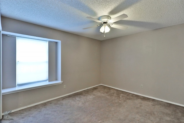 carpeted spare room featuring ceiling fan and a textured ceiling