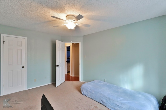 bedroom featuring ceiling fan, carpet floors, and a textured ceiling