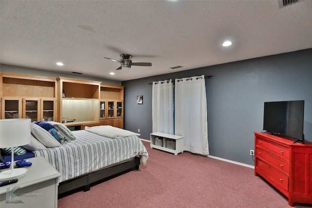 carpeted bedroom with ceiling fan and a textured ceiling