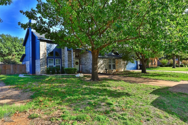 view of property hidden behind natural elements with a front lawn