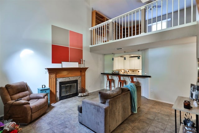 living room featuring a towering ceiling and a high end fireplace