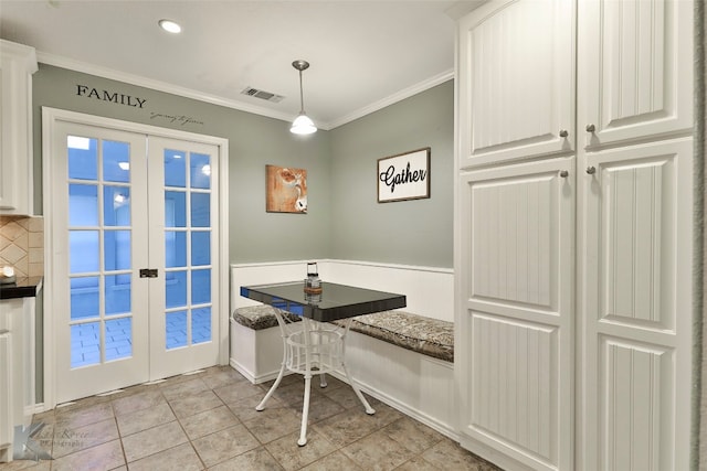 dining area featuring french doors, breakfast area, light tile patterned floors, and crown molding