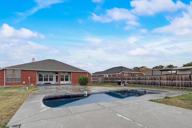 view of pool with a patio area and a lawn