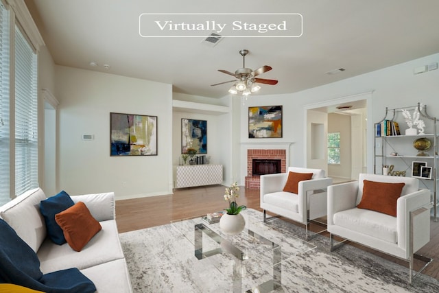 living room with a fireplace, ceiling fan, and dark wood-type flooring