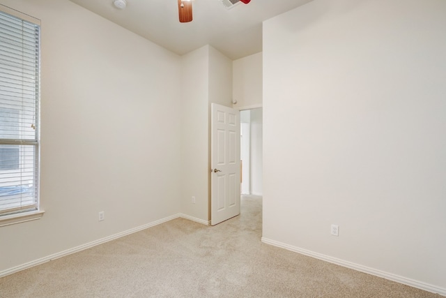 unfurnished room with ceiling fan and light carpet