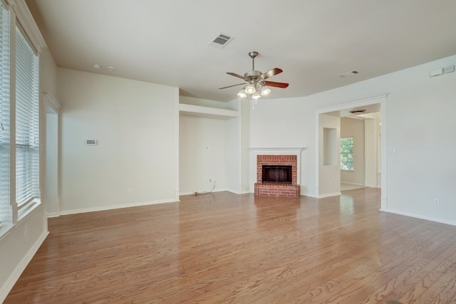 unfurnished living room with light hardwood / wood-style floors, ceiling fan, and a fireplace