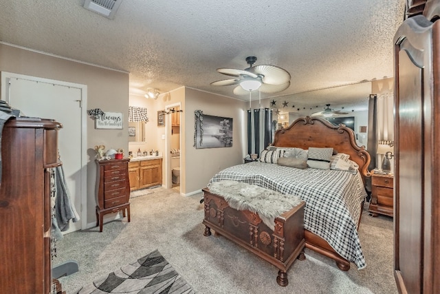 carpeted bedroom featuring ensuite bath, a textured ceiling, and ceiling fan