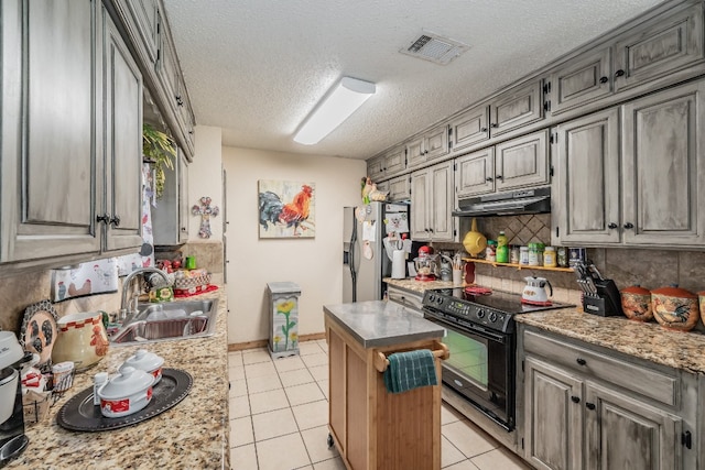 kitchen with a kitchen island, light tile flooring, stainless steel fridge with ice dispenser, black / electric stove, and sink