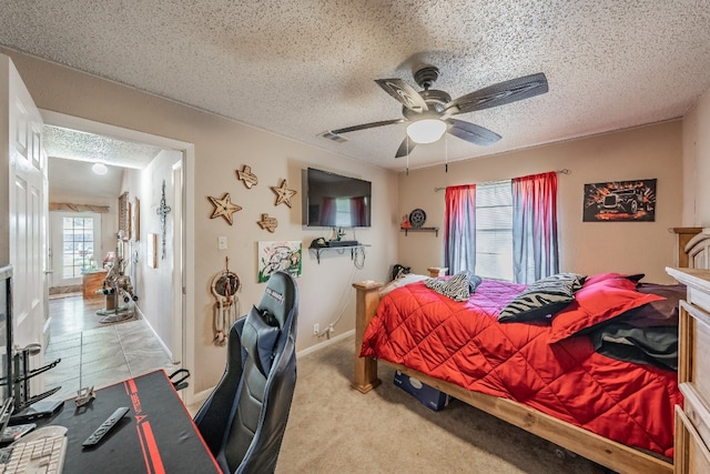 bedroom featuring light carpet, a textured ceiling, and ceiling fan