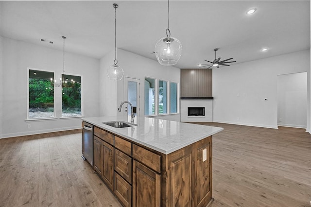 kitchen featuring sink, a healthy amount of sunlight, a center island with sink, and light wood-type flooring