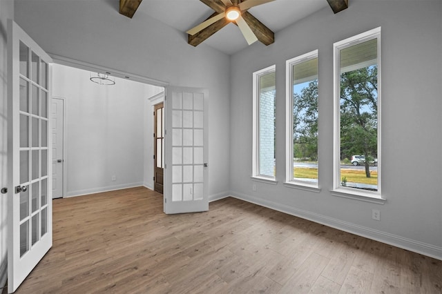 unfurnished room with light hardwood / wood-style floors, beam ceiling, and french doors