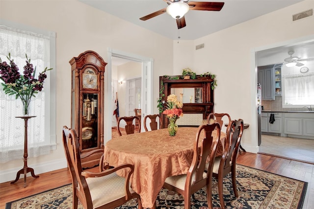 tiled dining room with ceiling fan and sink