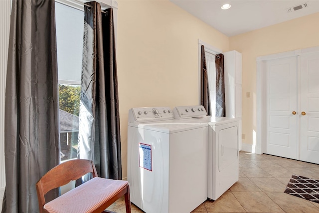 laundry room with washer and dryer and light tile floors