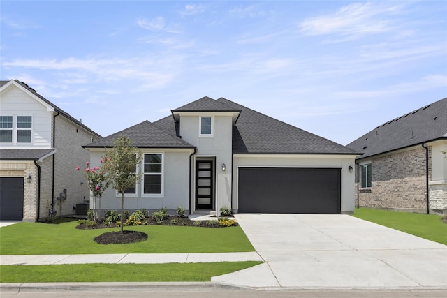 view of front of home with a garage, central AC, and a front lawn