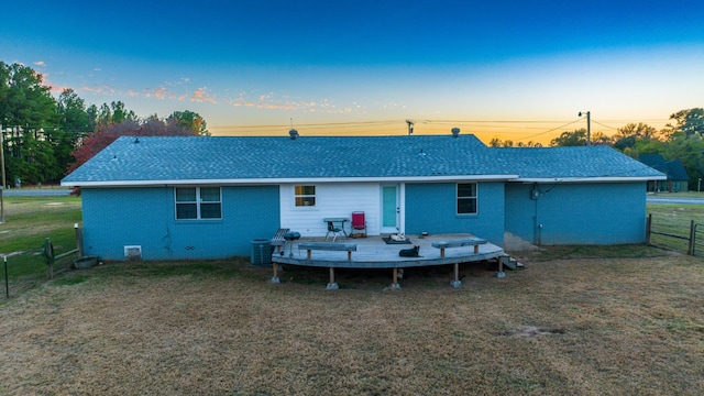 back house at dusk featuring a deck and central AC unit