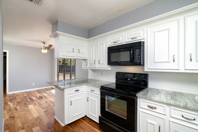 kitchen featuring hardwood / wood-style flooring, kitchen peninsula, black appliances, and white cabinetry