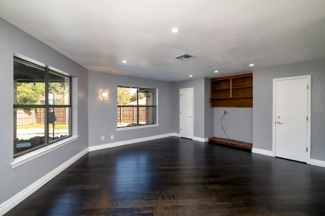 unfurnished living room with plenty of natural light and dark wood-type flooring