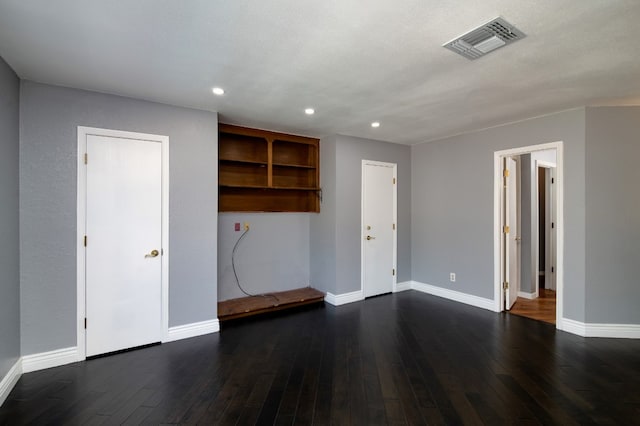 unfurnished living room with dark wood-type flooring