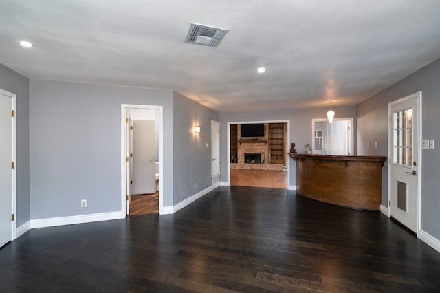 unfurnished living room with a textured ceiling and dark hardwood / wood-style flooring