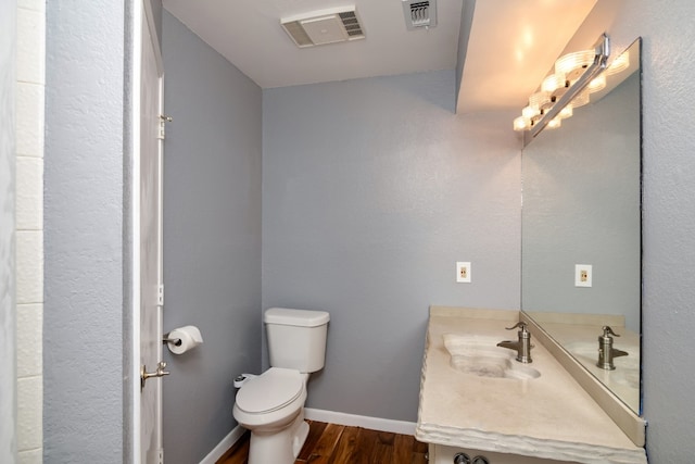 bathroom featuring vanity, wood-type flooring, and toilet