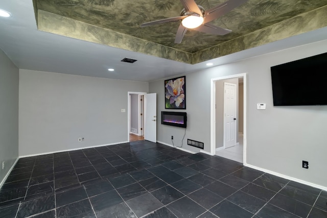 empty room featuring dark tile flooring and ceiling fan