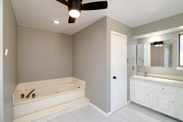 bathroom with a tub, tile floors, ceiling fan, and vanity with extensive cabinet space