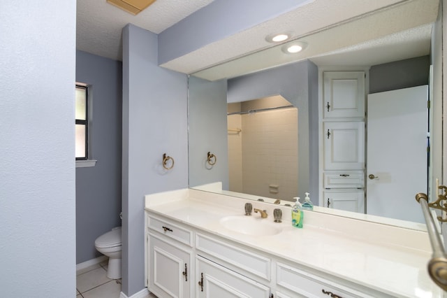 bathroom with tile floors, toilet, large vanity, and a textured ceiling