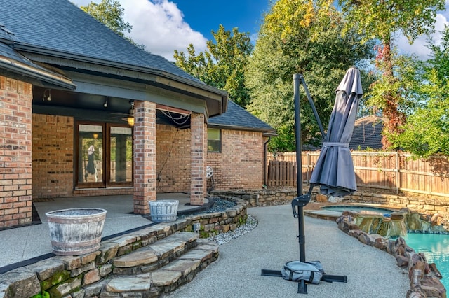 view of terrace with an in ground hot tub