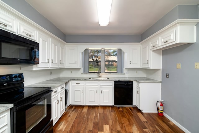 kitchen featuring white cabinets, dark wood-type flooring, and black appliances